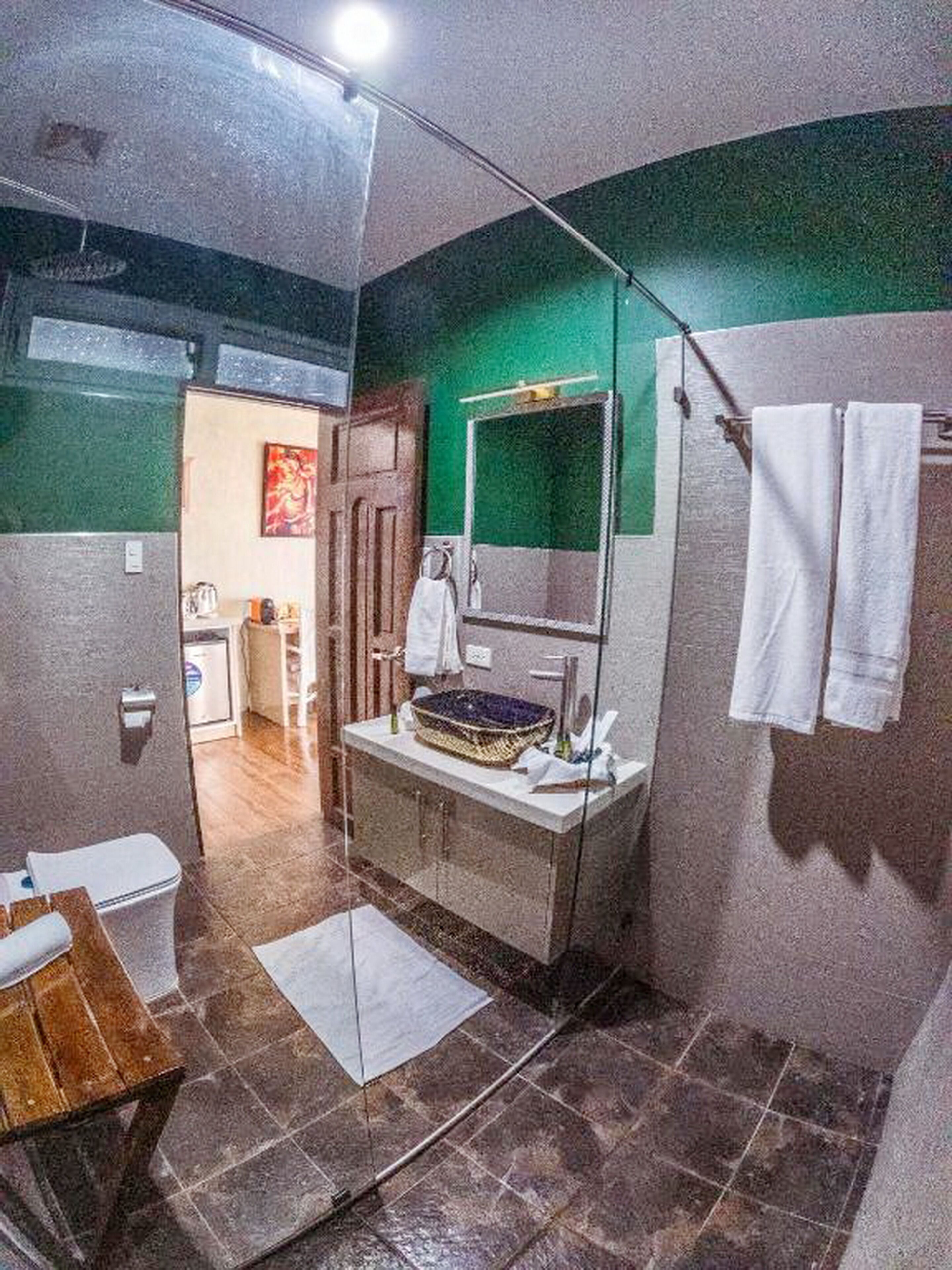 A bathroom with a glass shower enclosure, a sink with a decorative basin, and a towel rack.