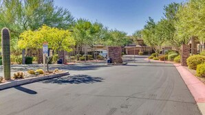 A gated entrance to a property with a paved driveway, a cactus, and a sign indicating a pet-friendly area. - Completely Remodel Condo, Sleep Number I-8 bed with adjustable firmness. (Cave Creek)