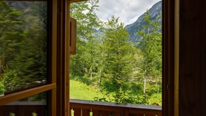 Un balcón de madera con vista a un paisaje montañoso.