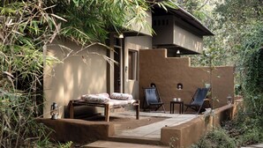 A rustic outdoor seating area with a sofa, two lounge chairs, and a small table. - Saccharum Safari Lodge (Baihar)
