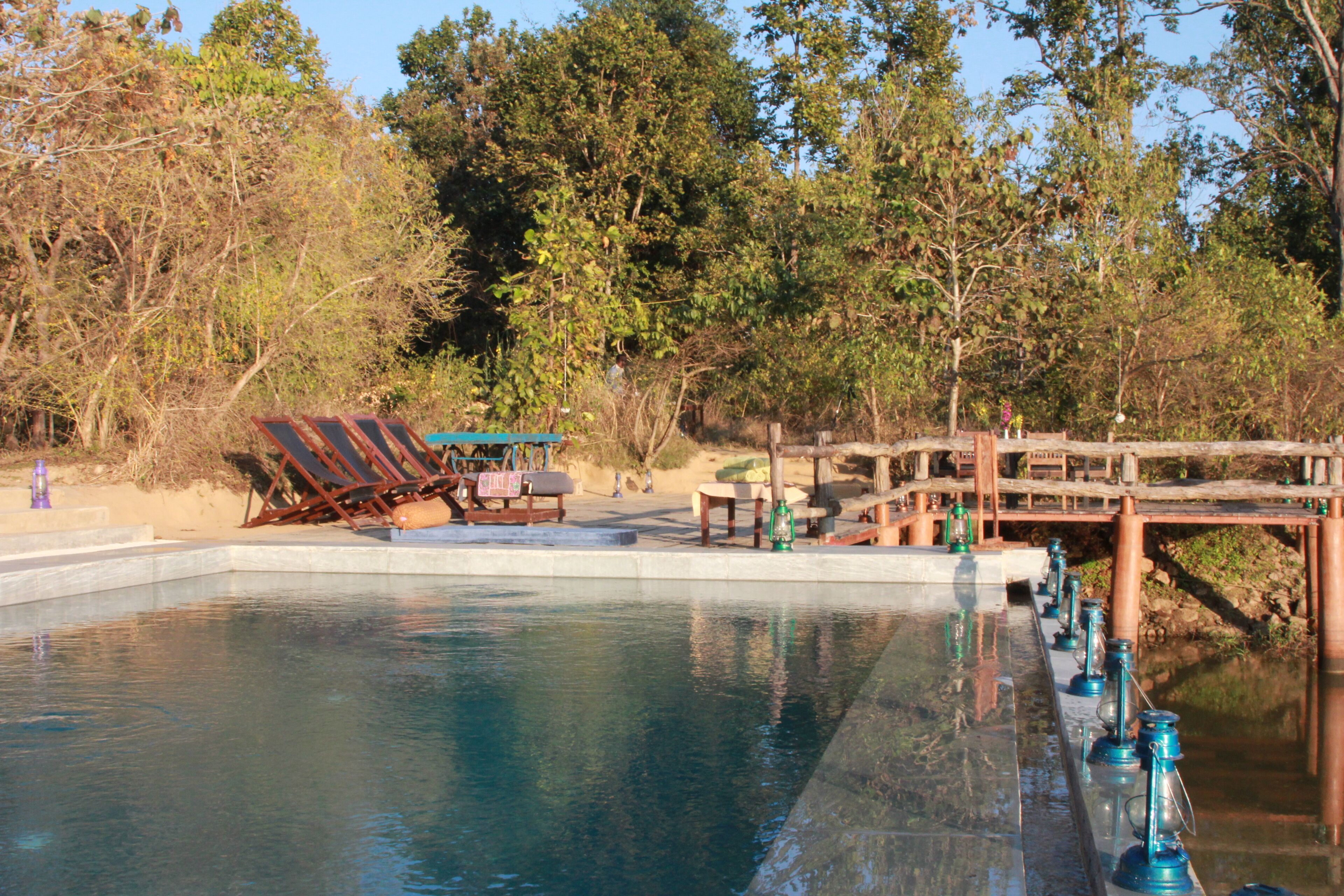 A swimming pool with lounge chairs and a wooden deck.