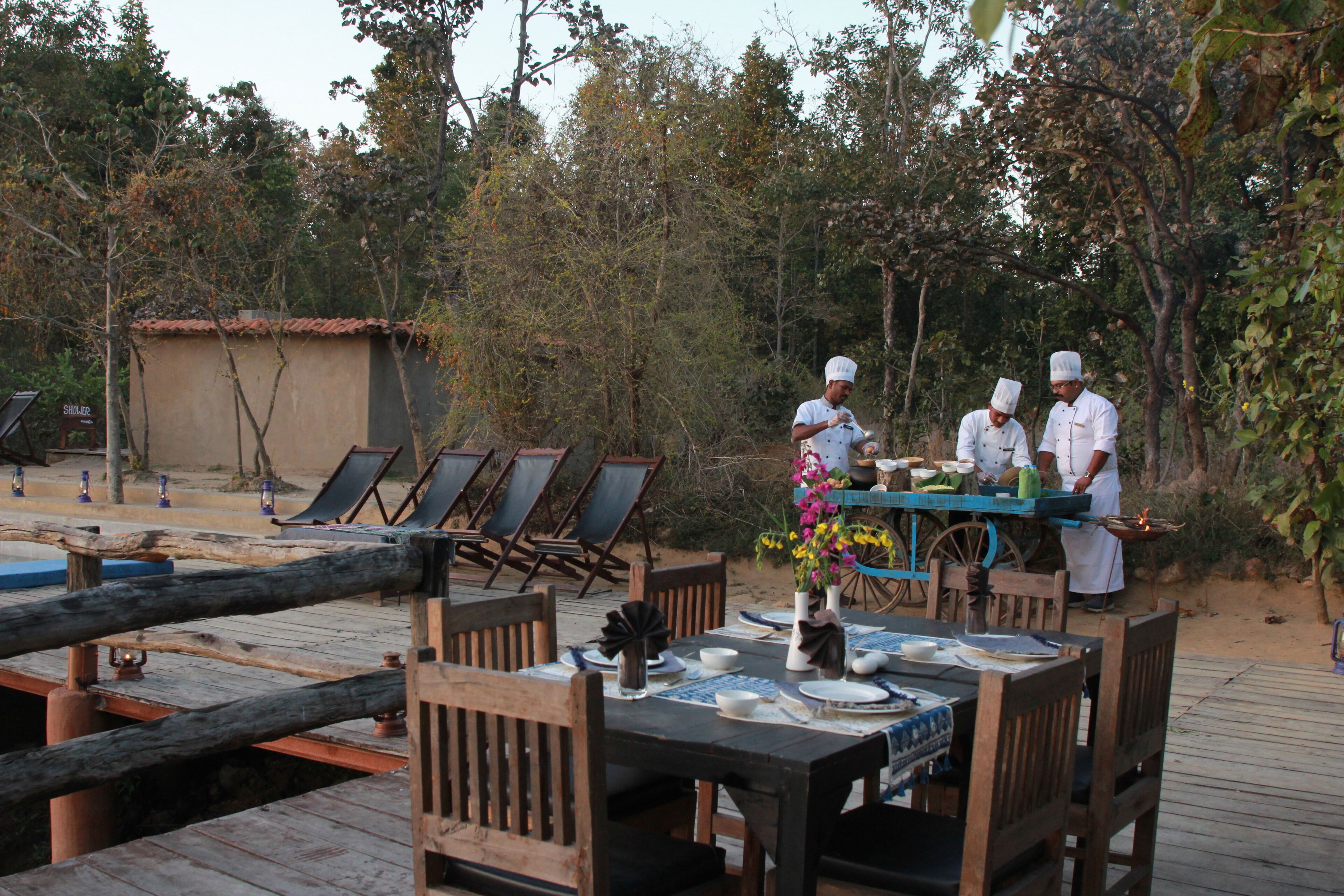 Comedor con mesas y sillas de madera, barra de buffet y ambiente junto a la piscina.