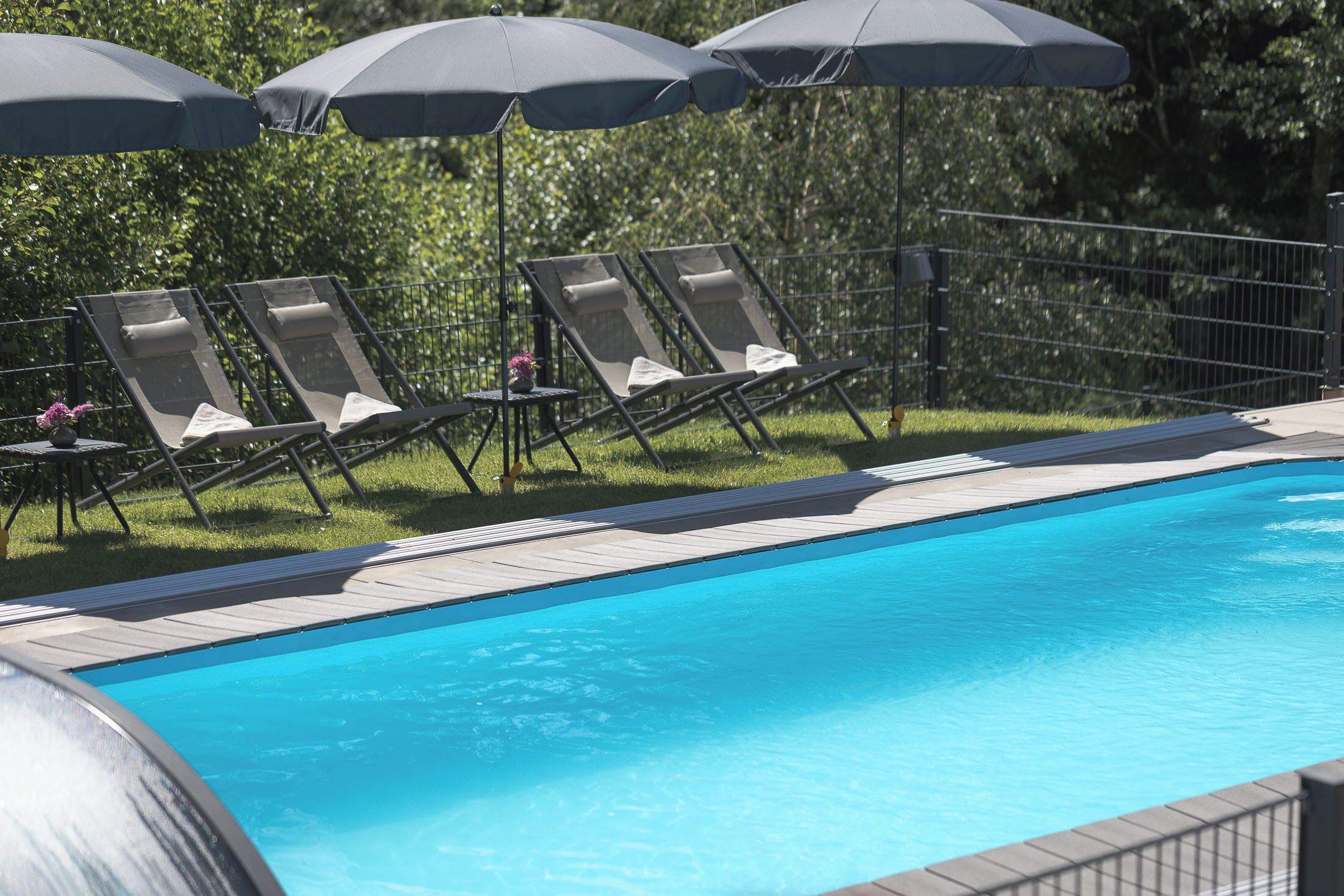 A swimming pool with lounge chairs and umbrellas.