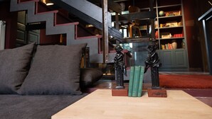 Een woonkamer met een bank, een salontafel en een trap.