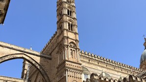 A historic building with intricate architectural details, including a prominent tower and arched structures.