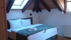 A bedroom with a bed, a skylight, and a hanging light fixture. - "Lichtenegg" apartment with garage in Merano (Merano)
