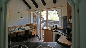 A compact kitchen with a dining area, wooden furniture, and a view through a glass door. - "Lichtenegg" apartment with garage in Merano (Merano)