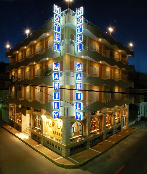 A multi-story hotel with neon signs spelling out "MARILYN HOTEL" on the facade. - Hotel Marily (Pyrgos)