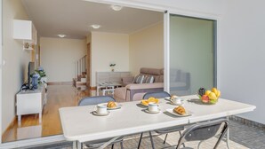 Un espace de vie moderne comprenant un coin repas, un canapé et un escalier menant à une autre pièce.