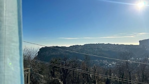 A view of a valley with a clear sky and a distant mountain range.