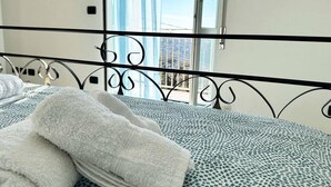 A bed with a patterned bedspread and two neatly folded towels.