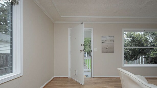 A room with wooden flooring, a white door, and a window with a view of trees. - A Home A Way from your Home with 3-bedroom & 2 bathroom with free parking  (Portland)