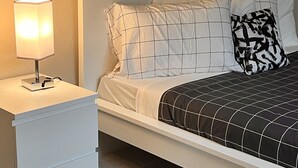 A neatly made bed with a black and white checkered bedspread and a black and white patterned pillow. - A Home A Way from your Home with 3-bedroom & 2 bathroom with free parking  (Portland)