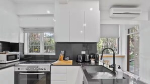 Een moderne keuken met een fornuis, een magnetron en een spoelbak.
