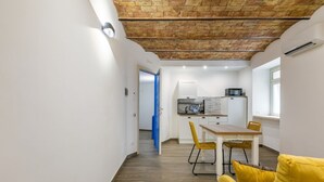 A modern kitchen with a microwave, a sink, and a dining area with yellow chairs. - GuestHost - Charming 60 sqm apartment, for 5 people, located on the 1st floor of a renovated period building (NO lift; 38 steps). The property is located in the center of Palermo (Restricted-Traffic Area), a few steps from the main attractions of the cit (Palermo)