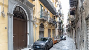 A narrow street with parked cars and buildings with balconies and shutters. - GuestHost - Charming 60 sqm apartment, for 5 people, located on the 1st floor of a renovated period building (NO lift; 38 steps). The property is located in the center of Palermo (Restricted-Traffic Area), a few steps from the main attractions of the cit (Palermo)