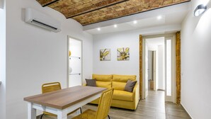 A modern interior with a dining table, yellow sofa, and artwork on the walls. - GuestHost - Charming 60 sqm apartment, for 5 people, located on the 1st floor of a renovated period building (NO lift; 38 steps). The property is located in the center of Palermo (Restricted-Traffic Area), a few steps from the main attractions of the cit (Palermo)
