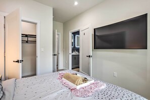 Een slaapkamer met een bed, een televisie en een kledingkast.