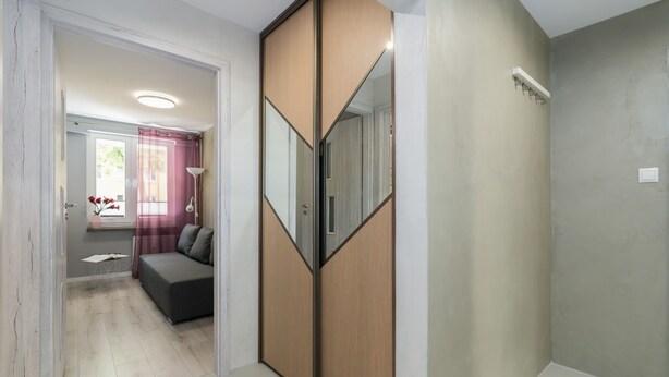 Een moderne kamer met een schuifdeurkast, een bank en een klein tafeltje.