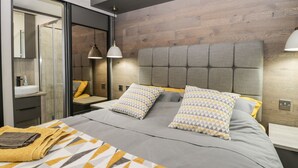 A modern bedroom with a bed, two bedside tables, a mirror, and a wooden headboard. - 59 Finch (Scarborough)
