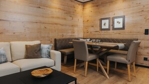 A cozy room with a sofa, a dining table with chairs, and a black coffee table.