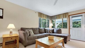 A living room with a sofa, a coffee table, a side table, and a lamp. - Brookside I B-405 - Sunday River Slopeside Condominium (Newry)