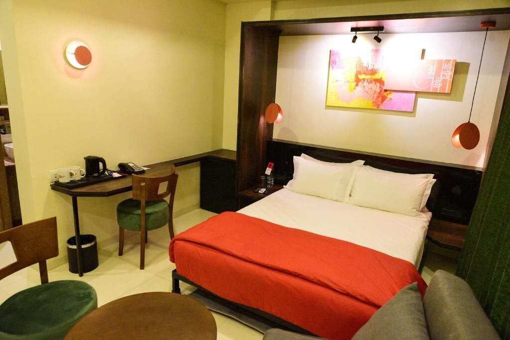 Una habitación de hotel con una cama, un escritorio, una silla y una mesita.
