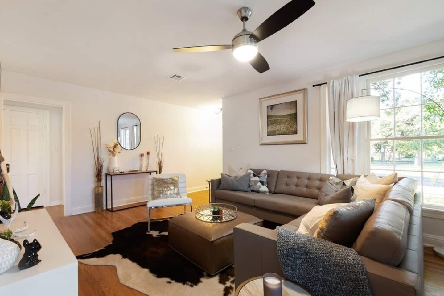 A modern living room with a sofa, coffee table, and a ceiling fan.