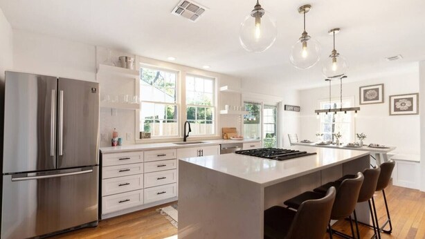A modern kitchen with a large island, stainless steel appliances, and pendant lighting. - Modern luxury with classic Fredricksburg charm just blocks from Main Street (Fredericksburg)