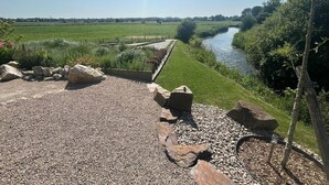 A gravel pathway leading to a river with a clear view of the landscape.
