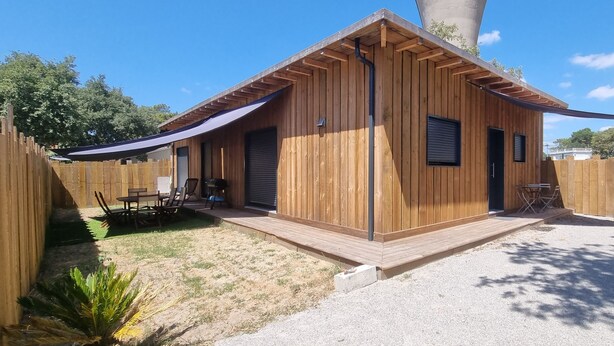 Eine Holzhütte mit überdachter Veranda, einer Tür und einem Fenster.