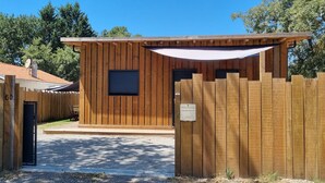 Eine Holzhütte mit überdachter Veranda, einem kleinen Fenster und einem Briefkasten.