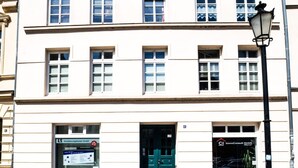 A building with a symmetrical facade, multiple windows, and a green door. - Wismarer-heckflosse (Wismar)