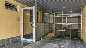 A building entrance with a glass door, a metal gate, and a tiled floor. - 'Loft Palamós' Apartment with A/C (Palamos)