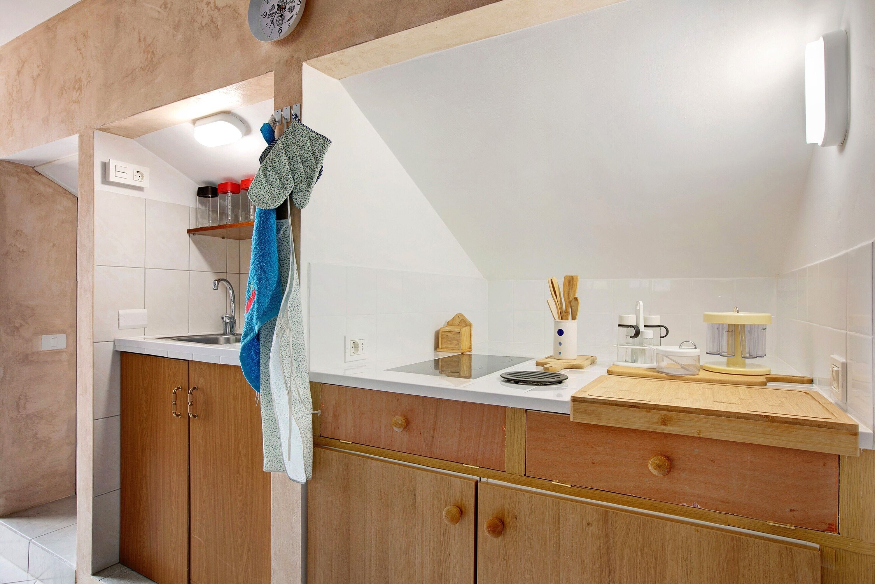 Una cocina con armarios de madera, encimera blanca y un lavabo.