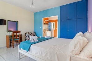 A bedroom with a bed, a desk, a chair, and a wardrobe.