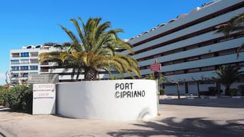 A building with a sign reading 'PORT CIPRIANO' and another sign indicating 'PROPRIETE PRIVÉ ATTENTION DE NUIT FERMETURE AUTOMATIQUE'.