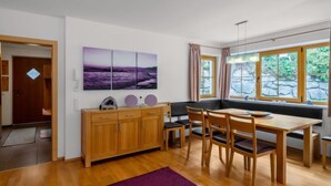 Une cuisine moderne avec des meubles de rangement en bois, une table à manger avec des chaises et un tapis violet.