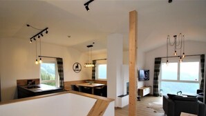A modern living space with a dining area, kitchen, and seating area.