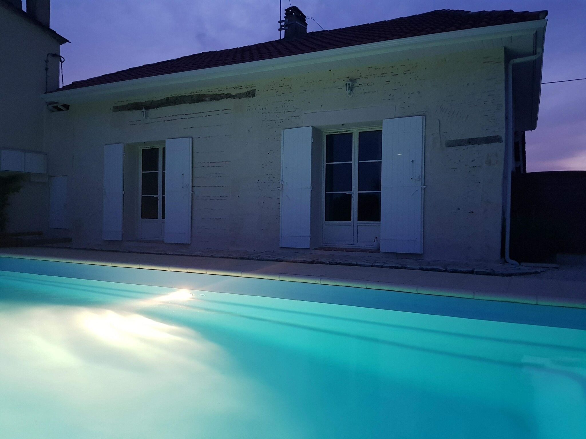 A building with a swimming pool in front.