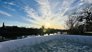 A hot tub with a view of a sunset over a body of water and trees. - House with private pool and jacuzzi, panoramic river view (La Force)