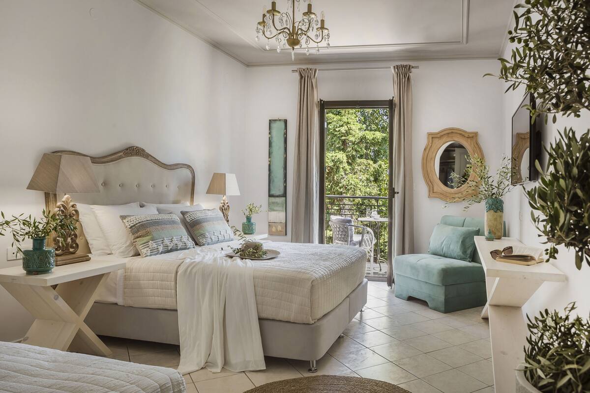 A bedroom with a bed, bedside tables, a chair, and a view of the outdoors.