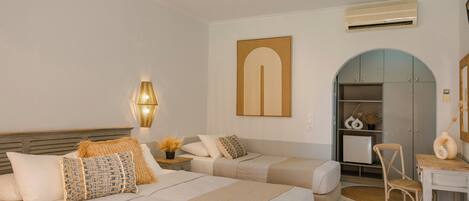 A hotel room with two beds, a desk, a chair, a wardrobe, and a wall-mounted air conditioner.