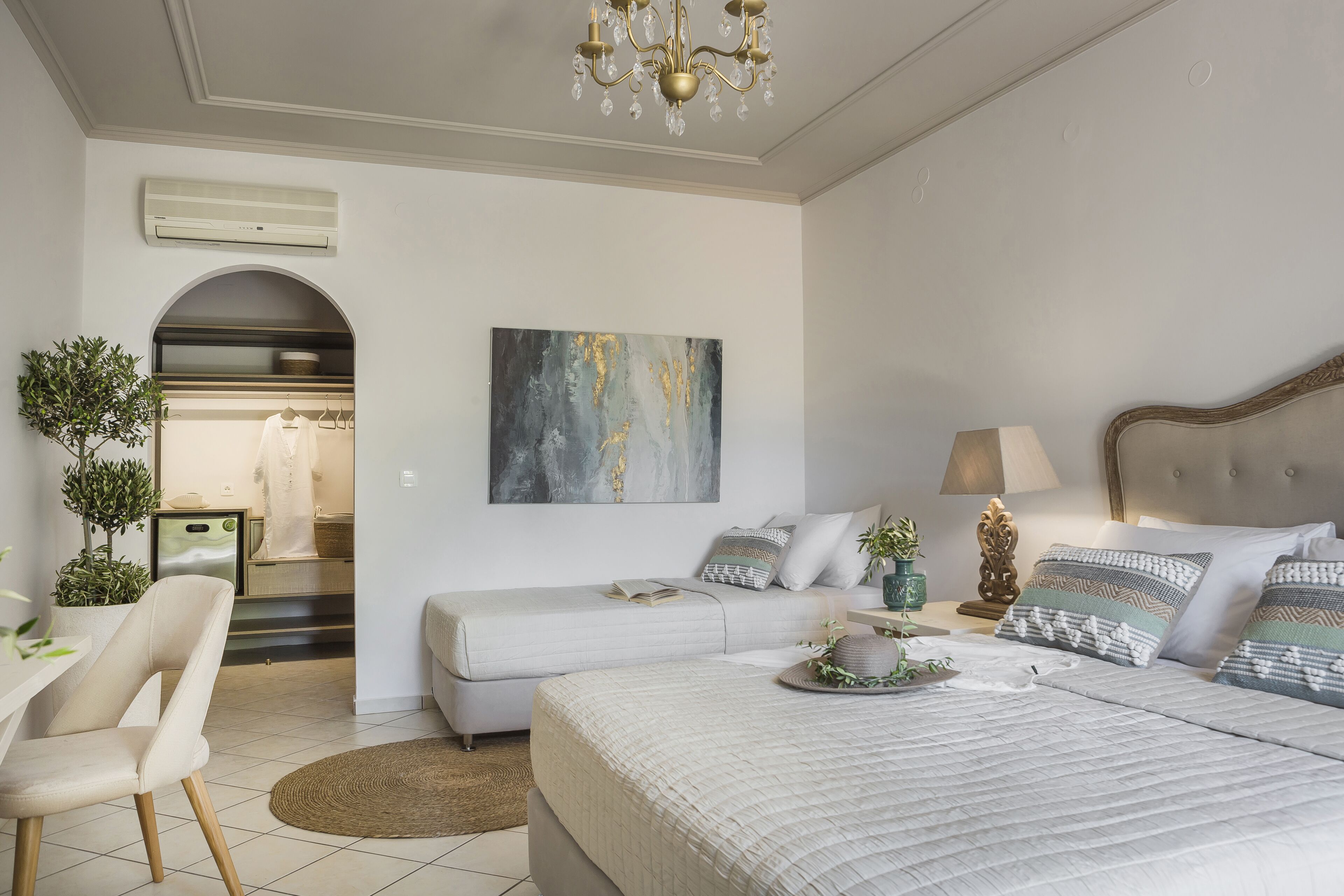Un dormitorio moderno con cama, mesita de noche, lámpara y un cuadro en la pared.