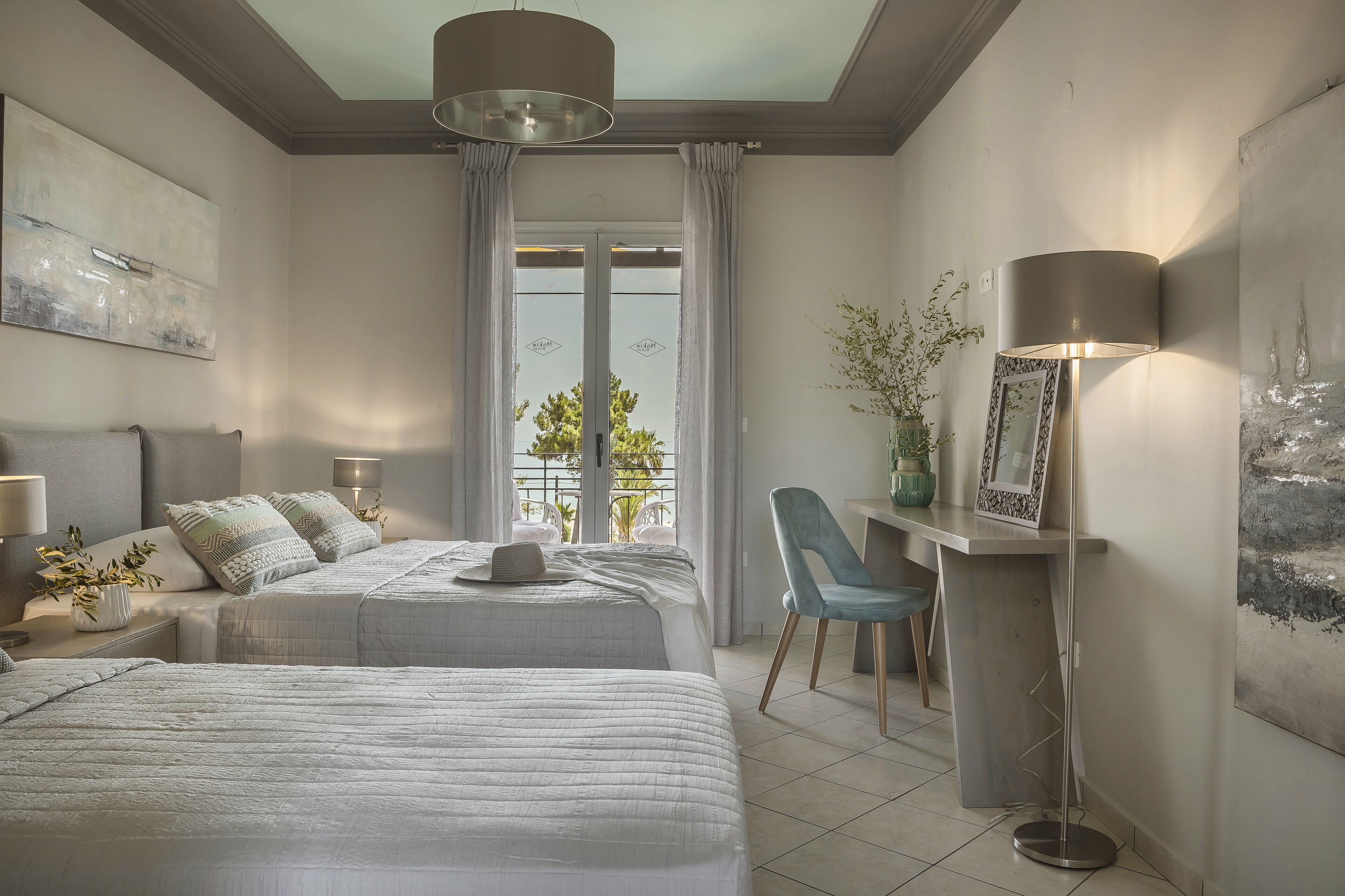 A modern bedroom with two beds, a desk, and a chair.