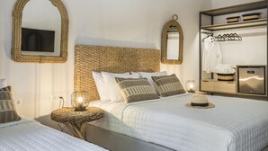 A hotel room with a large bed, a television, a mirror, and a wardrobe. - Makis Hotel Skala (Kefalonia)