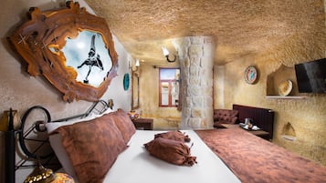 Un dormitorio con cama, espejo, lámpara y televisión.