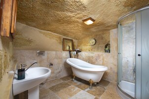 Un baño con bañera de patas de león, lavamanos y ducha.