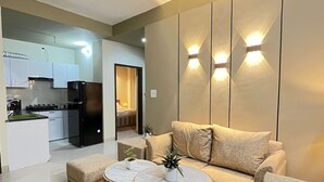 A modern living room with a sofa, two round coffee tables, and a patterned rug. - BedChambers Serviced Apartments Gurgaon (Gurugram)