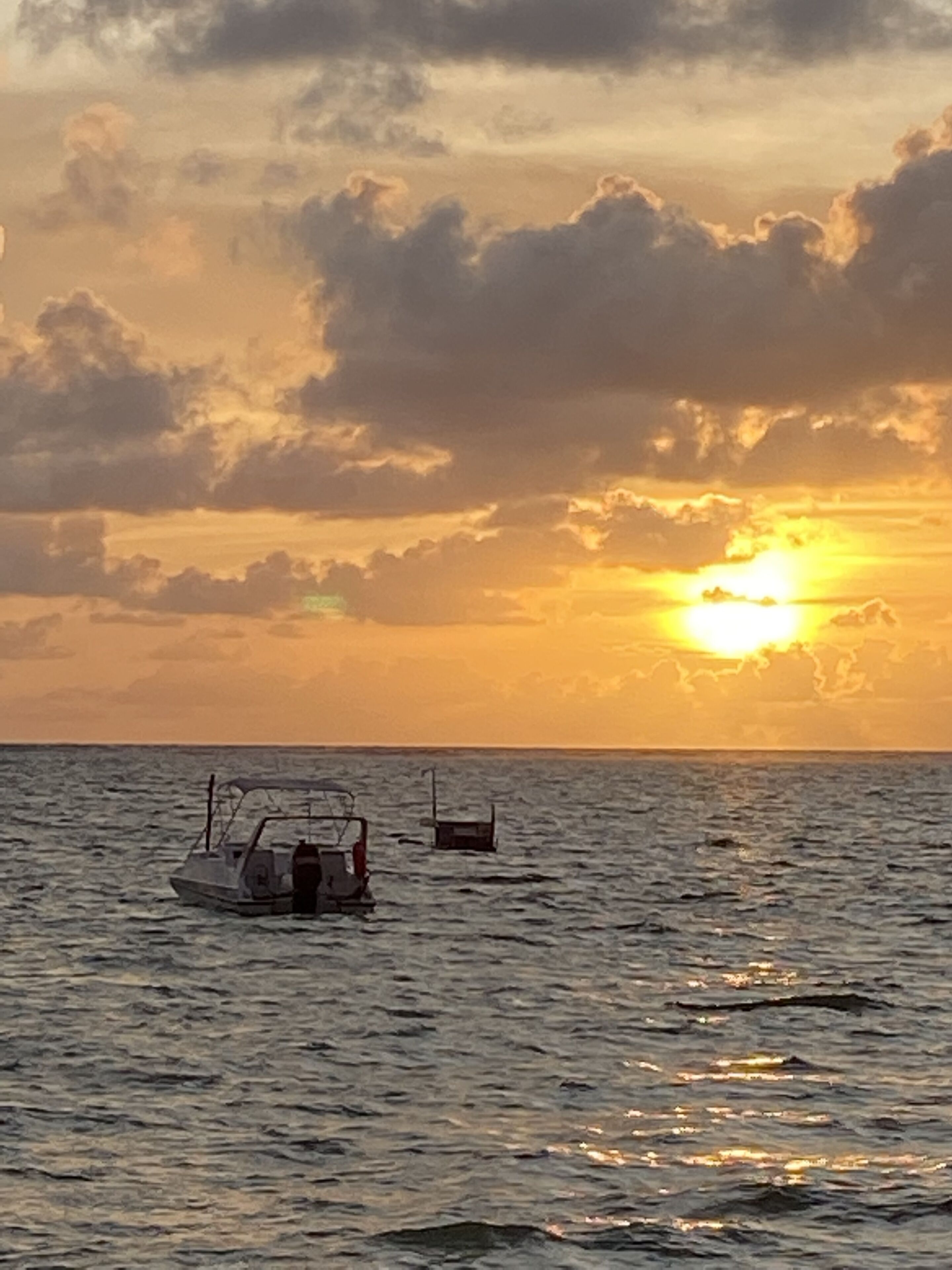 A boat on calm waters during sunset.